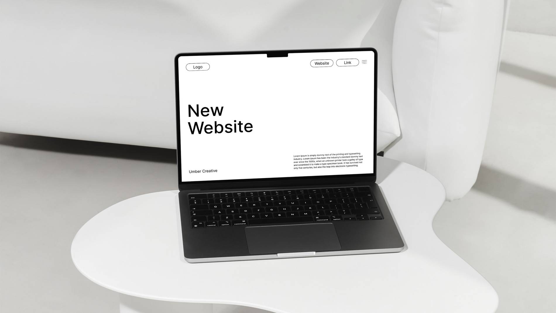 A sleek laptop on a white table displays a minimalistic webpage with "New Website" in bold text. The setting is modern and clean.