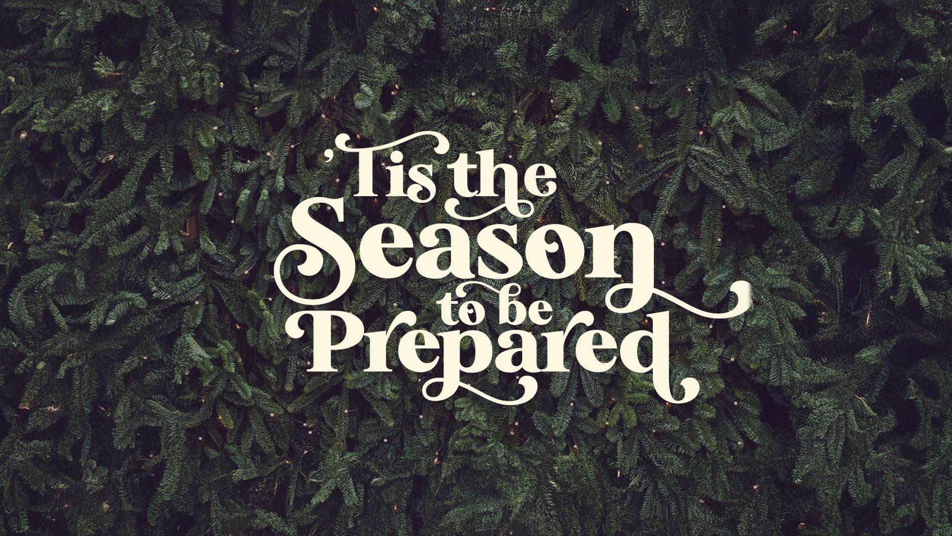 Elegant white text reading 'Tis the Season to be Prepared' overlays a lush evergreen background, evoking a festive and thoughtful atmosphere.